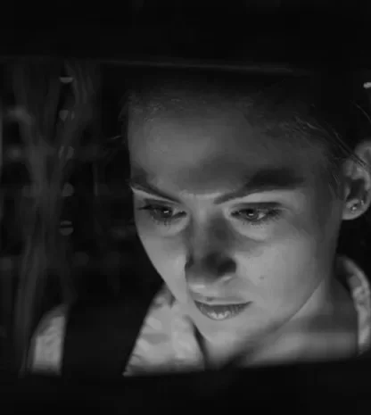IT professional inspecting server racks in a dimly lit data center.