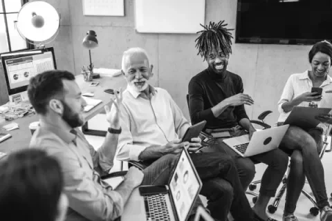 Group of people with laptops in a pleasant conversation