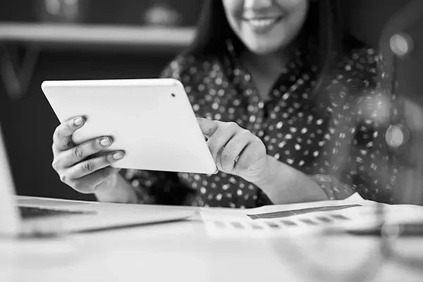 a smiling woman looking at a tablet