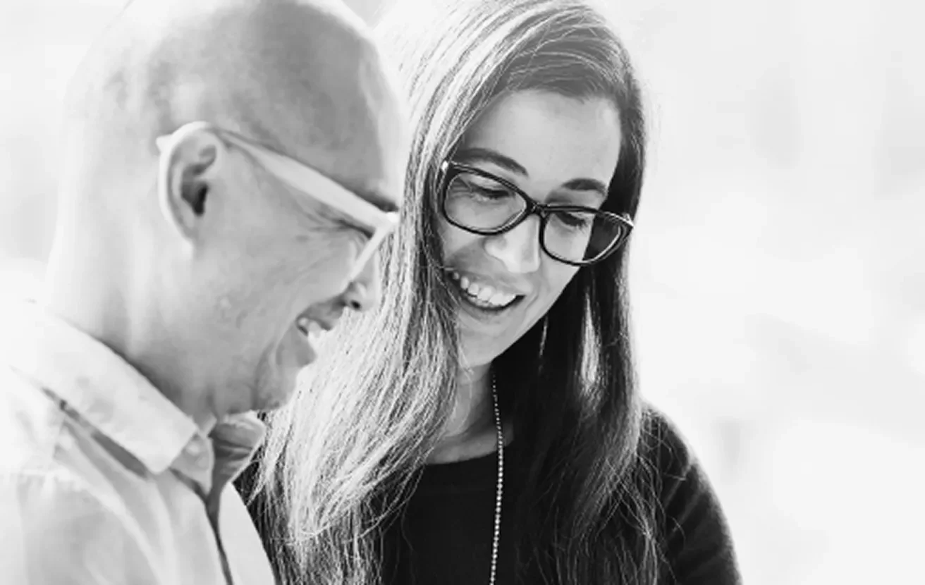 Two people smiling and reviewing information together, representing customer or technical support."